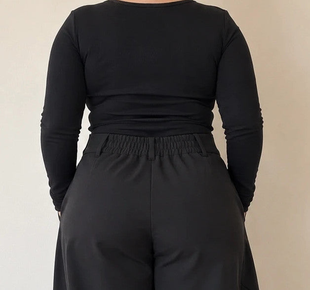 Wide leg black trousers with asymmetrical wrap design and overlapping waistband.