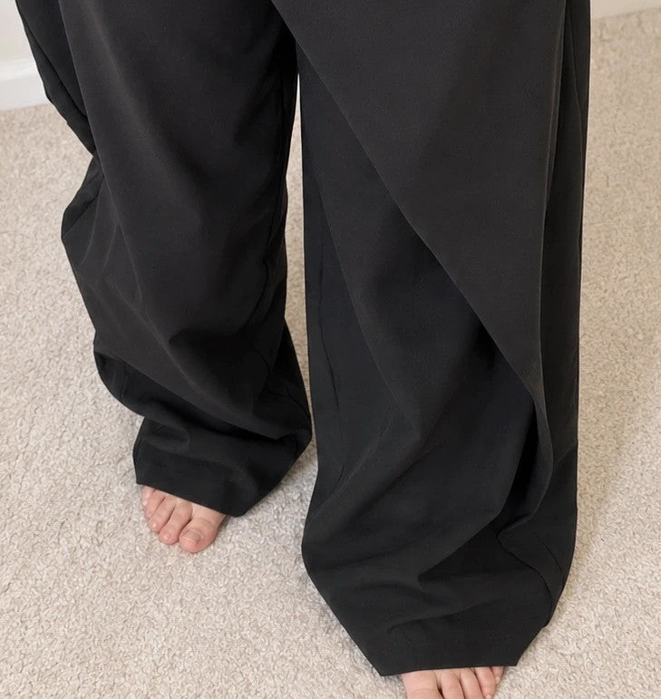 Wide leg black trousers with asymmetrical wrap design and overlapping waistband.