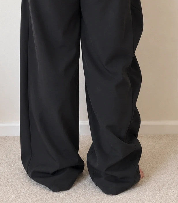 Wide leg black trousers with asymmetrical wrap design and overlapping waistband.